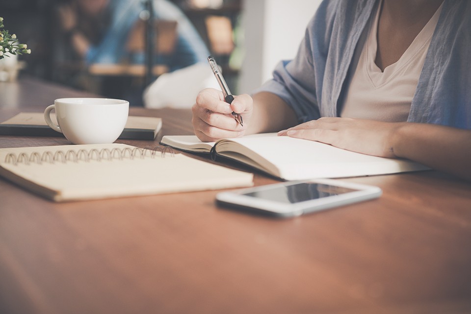 arranged notebooks and phone on a desk